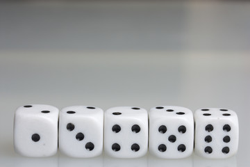 Dice. Playing cubes. Throwing the dice during the game. White cubes arranged in a row. On a white background. There is room for text.