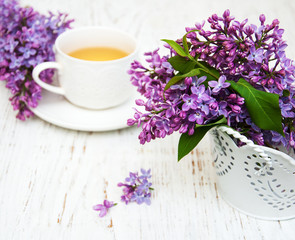 Cup of tea and lilac flowers