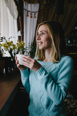 woman drinking coffee in the morning at restaurant (soft focus on the eyes)