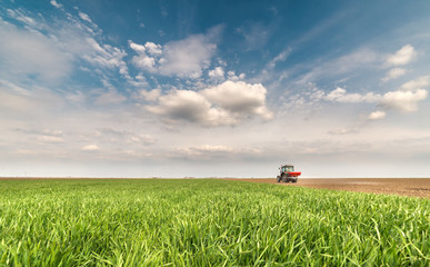 Fototapeta premium tractor fertilizing in field
