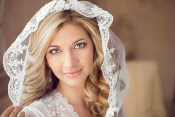 Beautiful bride with fashion wedding hairstyle in white veil. Cl