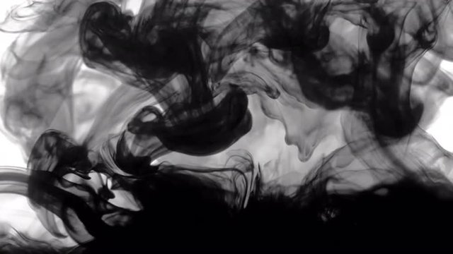 Swirling ink seen underwater in a glass tank, creating a black and white abstract background suitable for compositing and/or coloring.  Locked off, desaturated clip, originally recorded in 4K.