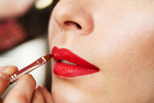 Lip makeup, red lipstick, lipstick brush, beautiful young brunette woman doing makeup