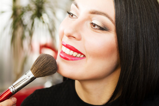 beautiful girl doing makeup,
brush for powder and blush, beauty salon