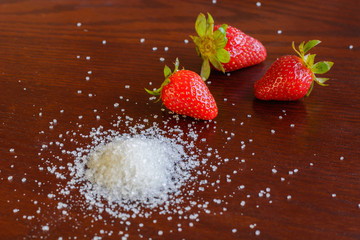 red jucy strawberry with white sugar on the table
