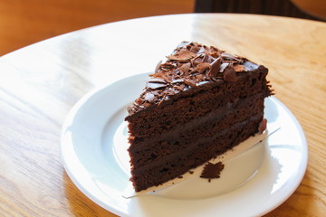 A piece of soft chocolate cake on white plate.