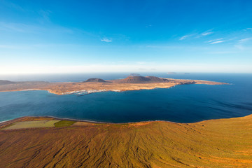 Fototapeta na wymiar Wide angle view on Graciosa island from El Rio viewpoint on Lanzarote island in Spain