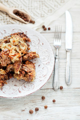 
Fried chicken liver with onions and spices on a wooden background