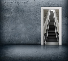 Concrete room with access to escalator through the doorway