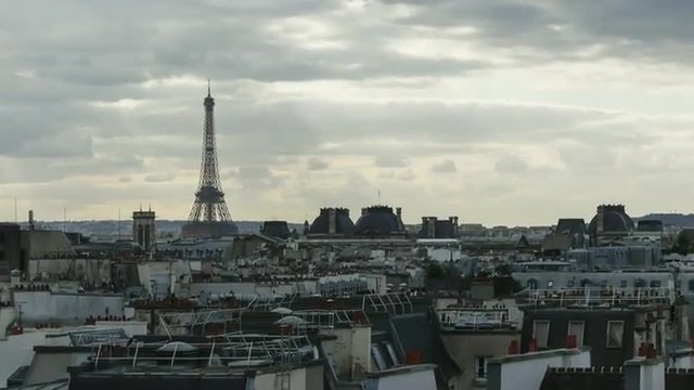 Timelapse shot of grey clouds floating over the Paris with following zooming in Eiffel Tower 