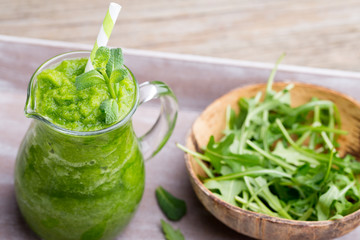 Rucola smoothie, on the grey  background.