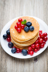 Stack of pancakes with blueberry and fresh berry.
