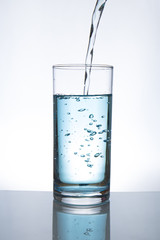 Concept of drinking. Pouring water from into glass