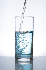 Concept of drinking. Pouring water from into glass
