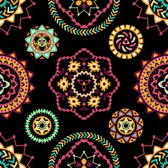 Seamless pattern of bright colorful geometric round ethnic decorative elements. Vector mandala background with bohemian, Oriental, Indian, Arabic, Aztec motifs.