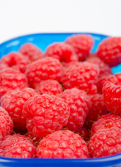 Ripe raspberries on blue basket cutout