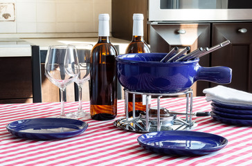 Special set of utensils for cooking fondue and white wine with two glasses