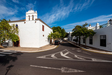 Fototapeta na wymiar Central square with church and traditional whitewashed buildings in Yaiza village on Lanzarote island in Spain