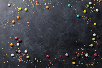 Rolgordijnen Colorful candies on stone background © karandaev
