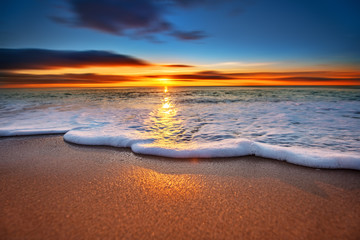 Sunrise light shining on ocean waves. - obrazy, fototapety, plakaty