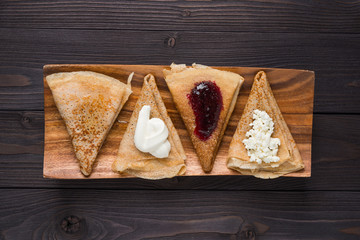 pancakes with filling on a wooden background