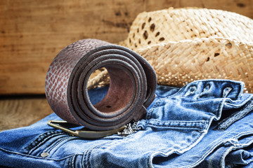 Jeans, straw hat, leather belt - women's clothes in cowboy count