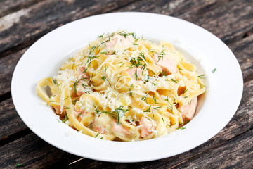 tasty pasta with salmon, dill on plate.