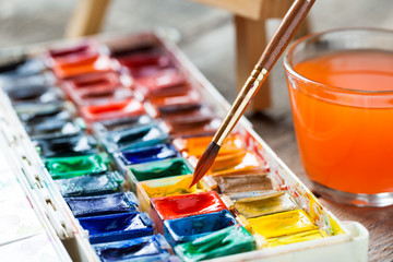 Fototapeta premium Set of watercolor paints and paintbrushes for painting closeup.