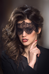 gorgeous woman brunette wears luxury evening dress and mask