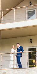 the bride and groom on a balcony