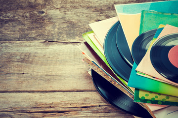 Old vinyl record on wooden background. Retro toned.