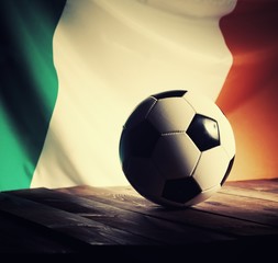 Flag of Ireland with football on wooden boards as the background. Vintage style.