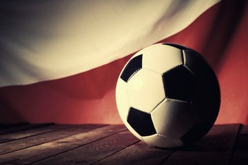 Fototapeta premium Flag of Poland with football on wooden boards as the background. Vintage Style.