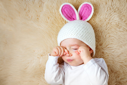 One Year Old Baby Lying In Bunny Hat On Lamb Wool