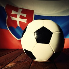 Obraz premium Flag of Slovakia with football on wooden boards as the background. Vintage Style.