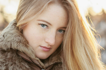 Fototapeta premium Portrait of smiling young woman with a fur collar