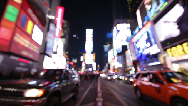 New York City, Times Square, Manhattan background out of focus with blurry unfocused city lights and billboards. City at night with cars and pedestrians people walking.