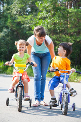 Mum learns to ride his little daughter and son on bike
