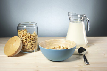 Delicious and healthy cereal in bowl with milk on table