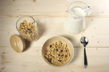 Delicious and healthy cereal in bowl with milk on table