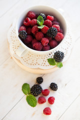 raspberry and BlackBerry in white plate , selective focus