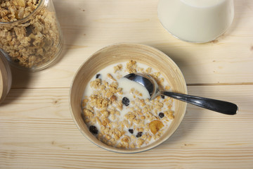 Delicious and healthy cereal in bowl with milk on table