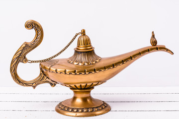 Aladdin magic lamp on white wooden background