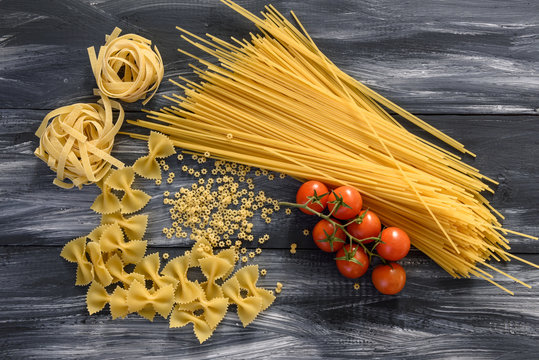 Pasta with tomatoes on wooden background