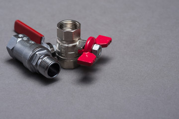 Water valves with red handle on grey