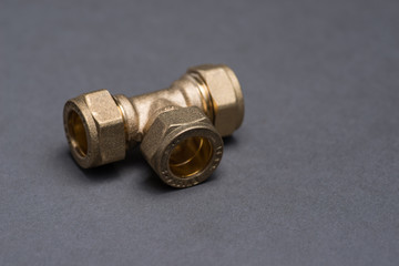 Brass plumbing compression fittings on grey table