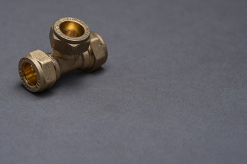 Brass plumbing compression fittings on grey table