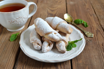 Bagels with jam in powdered sugar with tea for breakfast