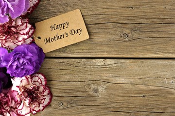 Happy Mothers Day gift tag with carnation flower side border on rustic wood background