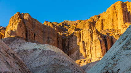 Fototapeta na wymiar Red Cathedral seen from the Golden Canyon trail. Narrow canyon with vertical walls on both sides. Rocky landscape background. Sandstone formations in Golden canyon, Death Valley